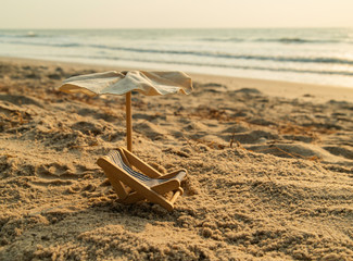 Fototapeta na wymiar Beach bed and umbrella on the beach with wave of sea
