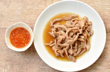 stewed duck intestine in brown soy soup on plate dipping spicy sauce