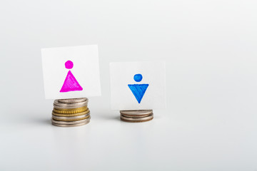 Woman figure standing on bigger stack of coins than man