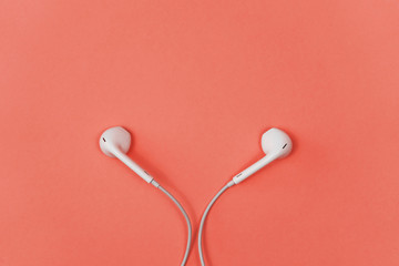 Headphones on a coral background. Color of the Year 2019 - living coral