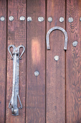 Old decorative door knocker and horseshoe on wooden door , Bulgaria