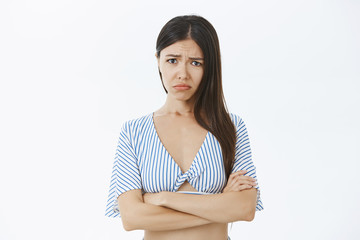 Silly whining girlfriend with long dark hair pursing lips and frowning complaining on unfair life...