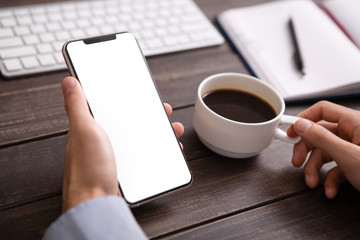 Man using blank smartphone and drinking coffee