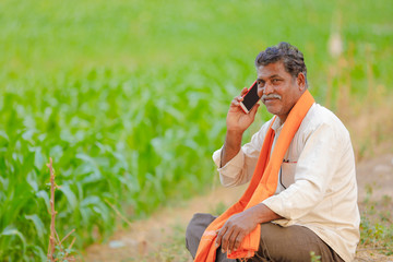Indian farmer using mobile phone at corn field