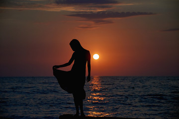 Woman watching sunset on the sea