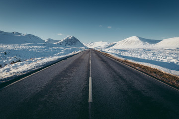 Open road winter snow mountain landscape in Glencoe Scotland