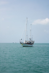 White sailboat swimming in the sea near the coast of Ko Samui island, Thailand