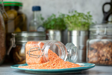 Dry red lentils in a jar on the kitchen table.