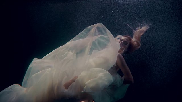 Female model underwater in dress floating lalone.