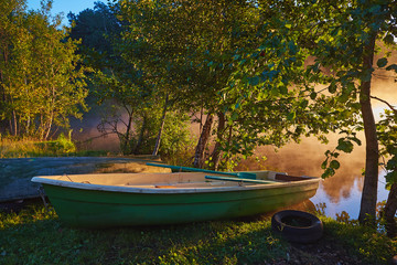 Peaceful morning landscape with fog and boats