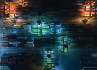 Aerial top view container warehouse in sea port at night for Logistics shipping, import export or transportation.
