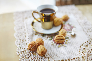 Traditional russian festive cookies "nuts" served with cofee in golden cup