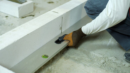checking evenness of aerated concrete wall with spirit level