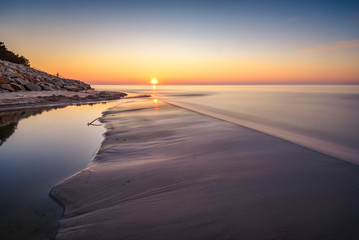 Fototapeta na wymiar Sunset over Baltic Sea. Sandy beach in Karwia village. Poland