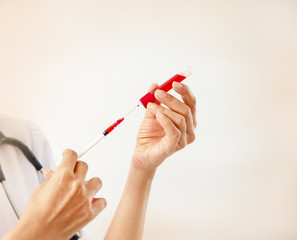 In selective focus of the syringe wirh  blood sample and vacuum tube,for lab test science,blurry light around