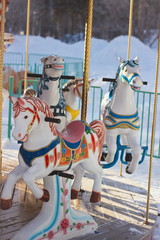 Outdoor colourful vintage flying horse carousel in the park