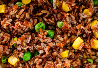 brown rice with green peas and corn, texture closeup background