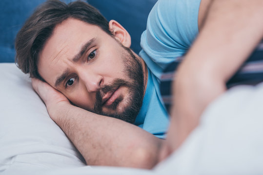 Selective Focus Of Depressed Man Grieving And Lying In Bed