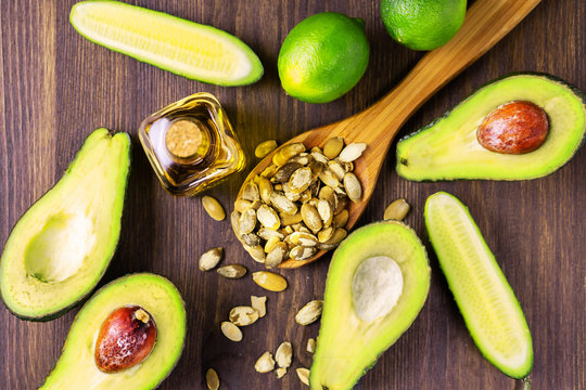 Avocado, Cucumber, Lime, Pumpkin Seeds And Oil On A Wooden Table, Healthy Food.