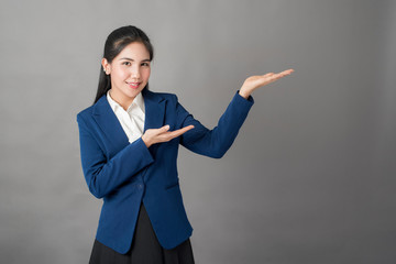 Portrait of smart  business woman in blue suit on grey background, studio shot