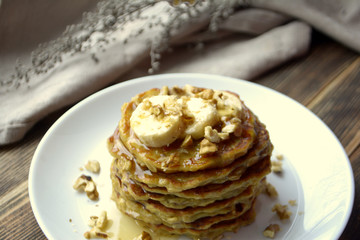 Stack of oatmeal pancake with banana, nuts and honey Healthy Breakfast	