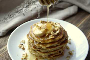 Stack of oatmeal pancake with banana, nuts and honey Healthy Breakfast	