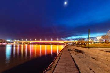 Belgrade, Serbia - February 10, 2019: The Gazela Bridge (Serbian: Most Gazela) is the most important bridge over the Sava river in Belgrade. A panorama of Belgrade by night with reflection in water.