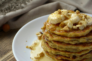 Stack of oatmeal pancake with banana, nuts and honey Healthy Breakfast