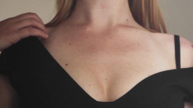 Young Caucasian Woman Wearing Black Evening Low Neck Dress Seductively Take Clothes Off Her Shoulders