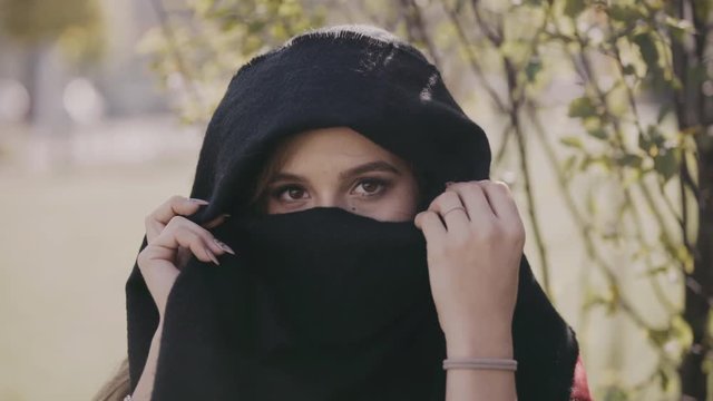 Portrait of the girl with beautiful eyes looks through the paranja