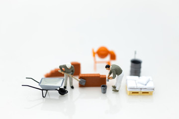 Miniature people: Construction workers building plans , have building materials, sand, brick,...