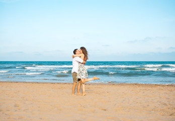 Fototapeta na wymiar Euphoric young couple meeting and hugging on the sea beach. Horizontal shape, side view, copy space