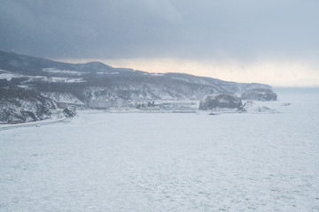 冬の知床　雪が舞うオホーツク海の流氷　（北海道・斜里町・ウトロ）