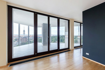 Modern white empty loft apartment interior with parquet floor with black column and panoramic windows, Overlooking the metropolis city