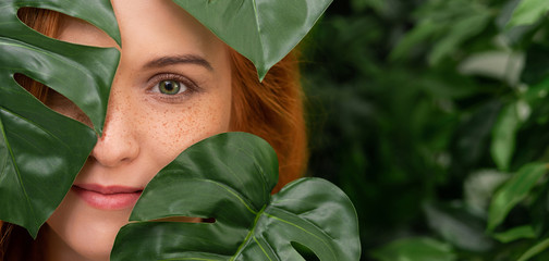 Portrait of young and beautiful woman in tropical leaves © Prostock-studio