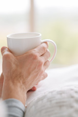 Morning coziness. Tea in man hands. Relaxing with cup of favorite drink.