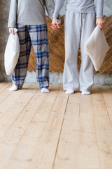 Restless night. Internet addiction. Couple standing with pillows in hands.