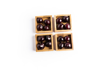 group of fresh red cherries in a wooden square bowls