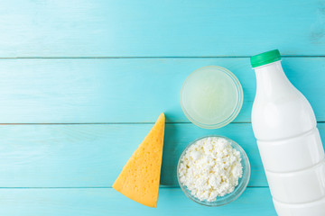 Dairy products. Milk, kefir, cottage cheese, cheese and whey on blue wooden background.