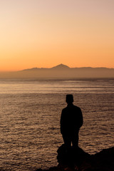 Silhouette Man Standing By Sea Against Clear Sky During Sunset