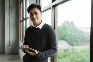 handsome asian young businessman using tablet pc