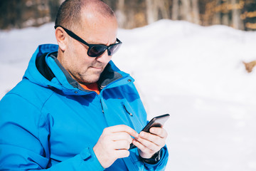 Hiker holding mobile phone and writing a message