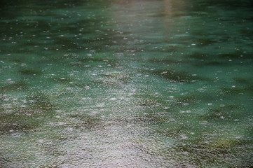 raindrops on the water surface of a deep blue lake