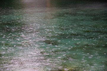 raindrops on the water surface of a deep blue lake