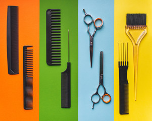 Fototapeta premium Eight tools hairdresser on the background of pastel paper in the form of multi-colored stripes. Minimalist pop art concept. Barbershop.