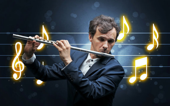 Young handsome flautist playing with music sheet background