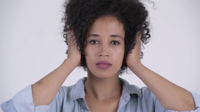 Face of young beautiful African woman covering ears as three wise monkeys concept