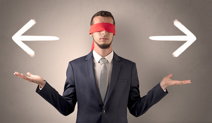 Covered eye businessman choosing between two directions 