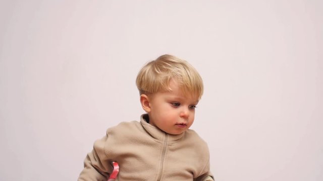 cute 2 years old boy falls down with chair white screen slow motion