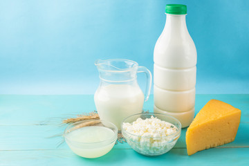 Dairy products. Milk, kefir, cottage cheese, cheese and whey on blue wooden background.